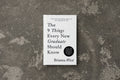 Book titled 'The 9 Things Every New Graduate Should Know' by Brianna Wiest on a textured gray surface