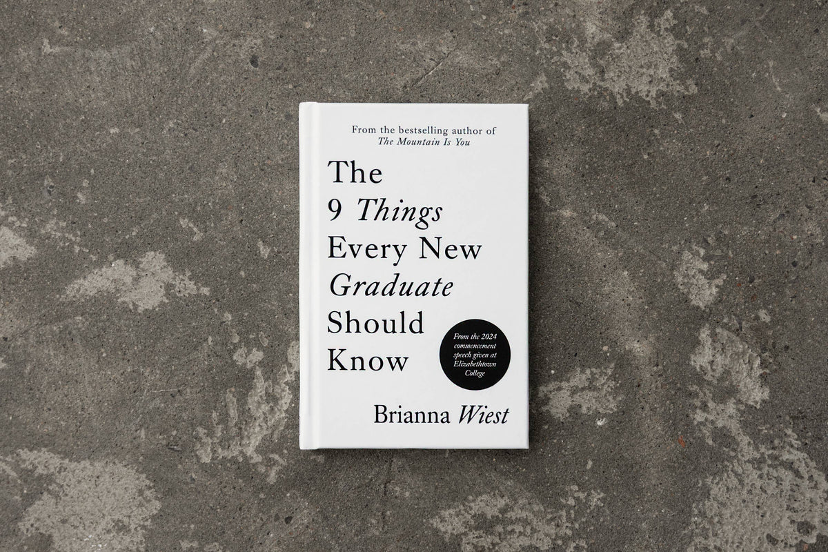 Book titled 'The 9 Things Every New Graduate Should Know' by Brianna Wiest on a textured gray surface