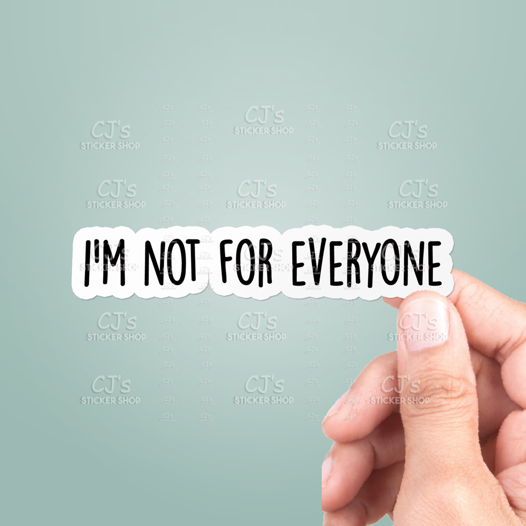 Hand holding a sticker with 'I'm not for everyone' text against a light gray background.