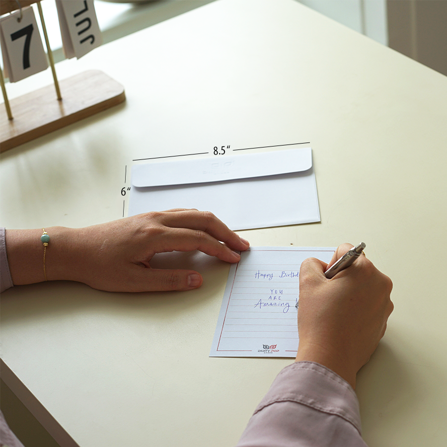 Person writing on a notepad with an envelope and ruler on a desk