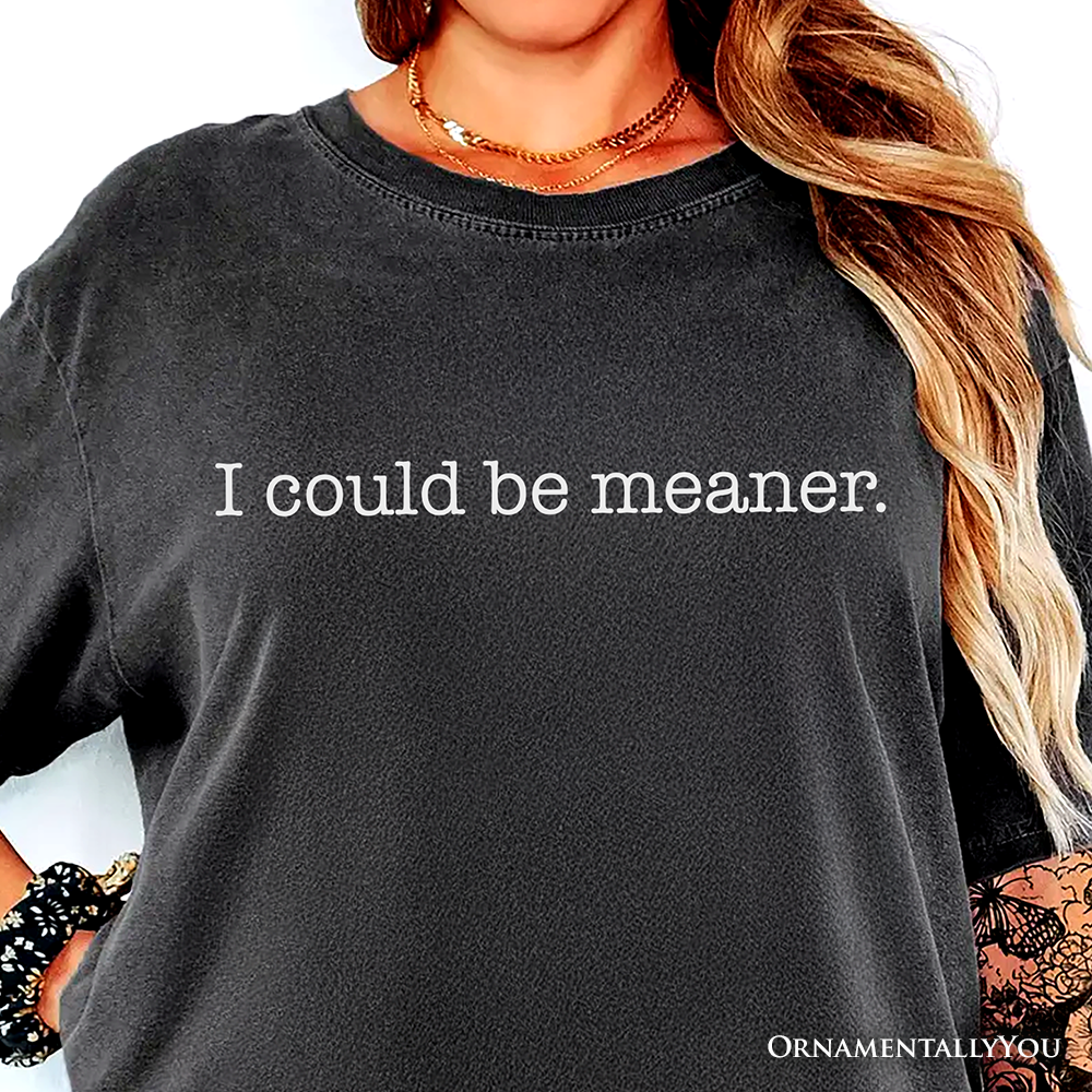 Black sweatshirt with 'could be meaner.' text worn by a person with long hair.