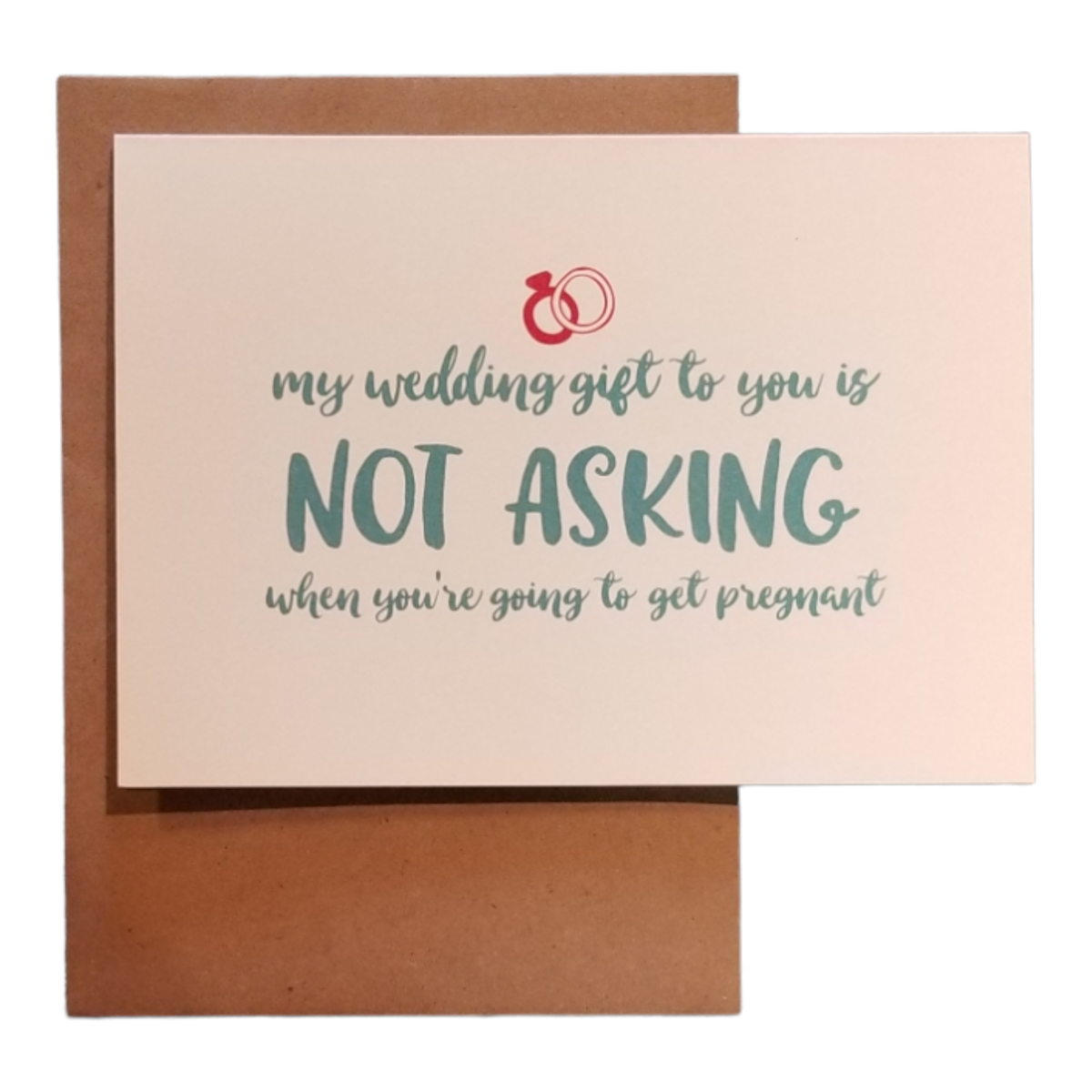 Card with text 'My wedding gift to you is not asking when you're going to get pregnant' on a beige background with a brown envelope.