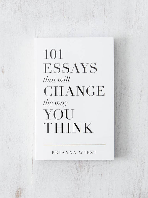 Book titled '101 Essays that will Change the Way You Think' by Brianna Wiest on a light wooden surface.