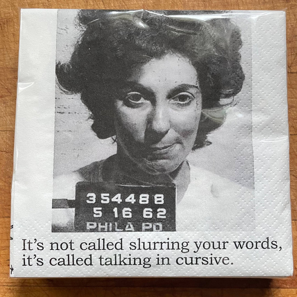 Mugshot of a woman on a napkin with text underneath