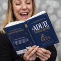 Person holding two copies of 'Adult Nursery Rhymes' book with a blurred background