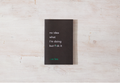 Black book with text on a light wooden surface