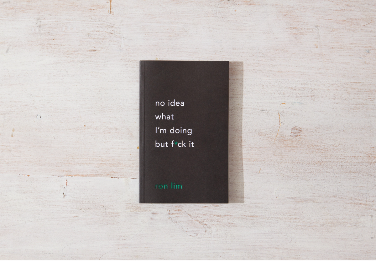 Black book with text on a light wooden surface