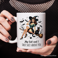 Mug with a witch and cat design and text, held by hands with decorative nails.