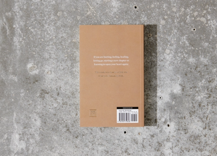 Brown notebook with text on a gray concrete surface
