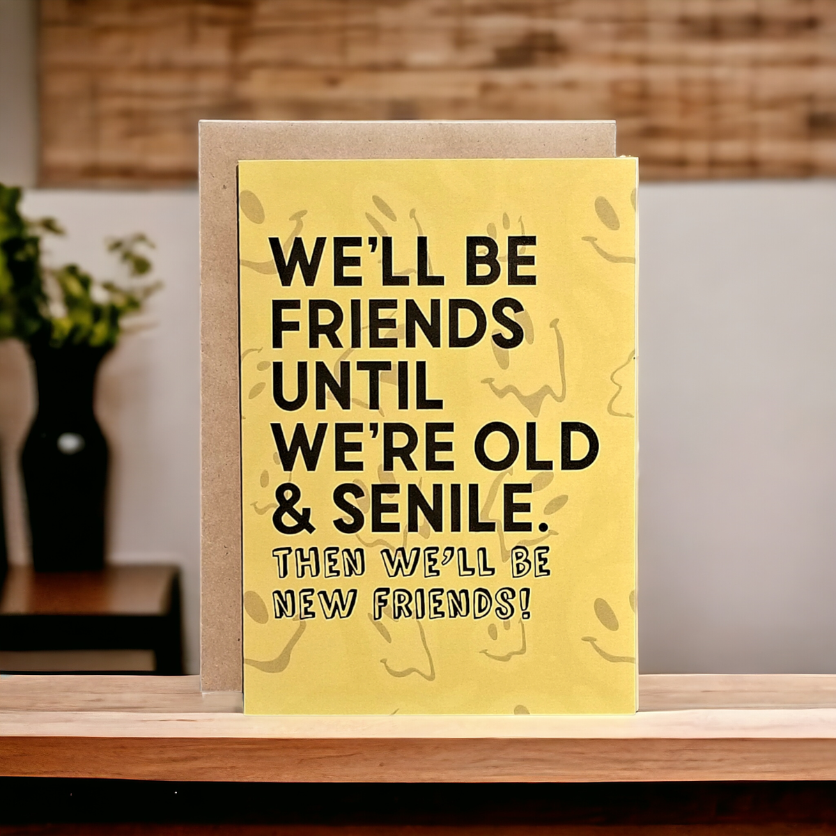 Greeting card with humorous text on a wooden surface with a blurred background
