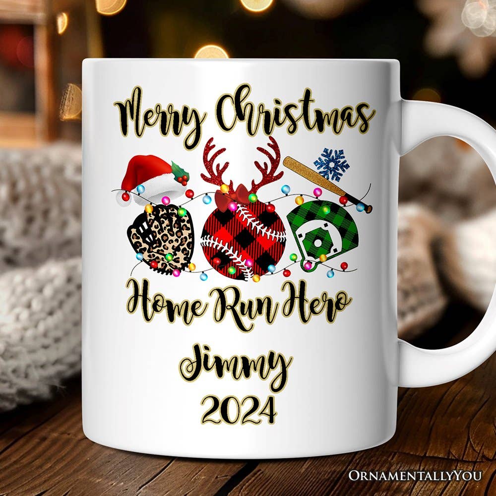 A white ceramic mug with a custom Christmas baseball graphic and the text 'Merry Christmas Home Run Hero Jimmy 2024' in black and gold lettering. The mug is displayed on a wooden surface with a cozy, blurred background.