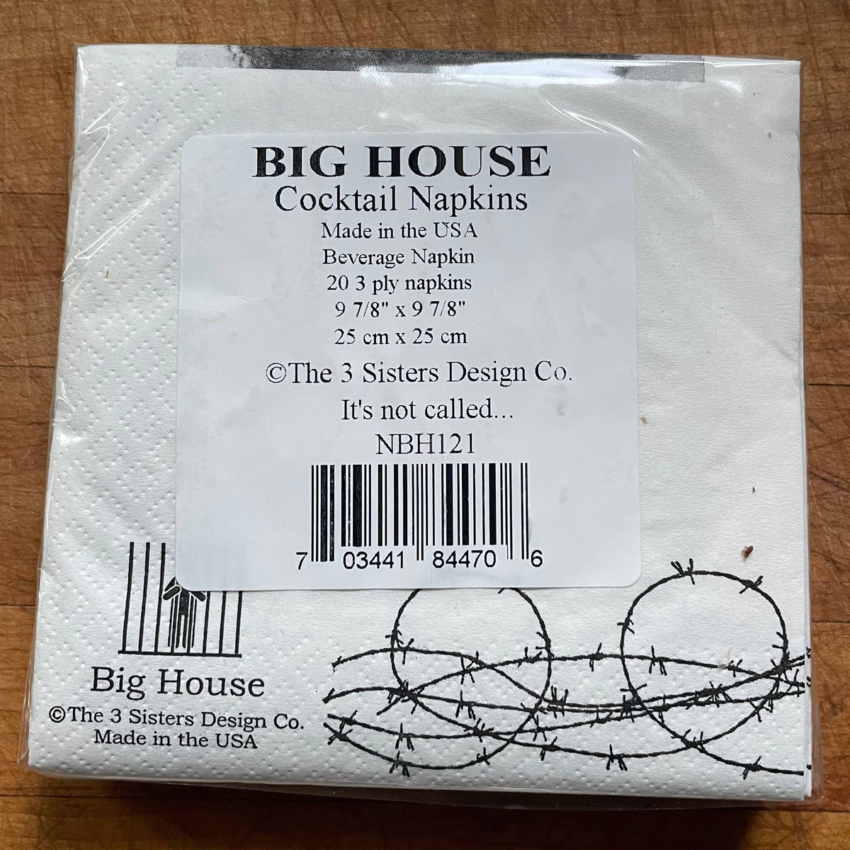 Packaged cocktail napkins with branding and product details on a wooden surface