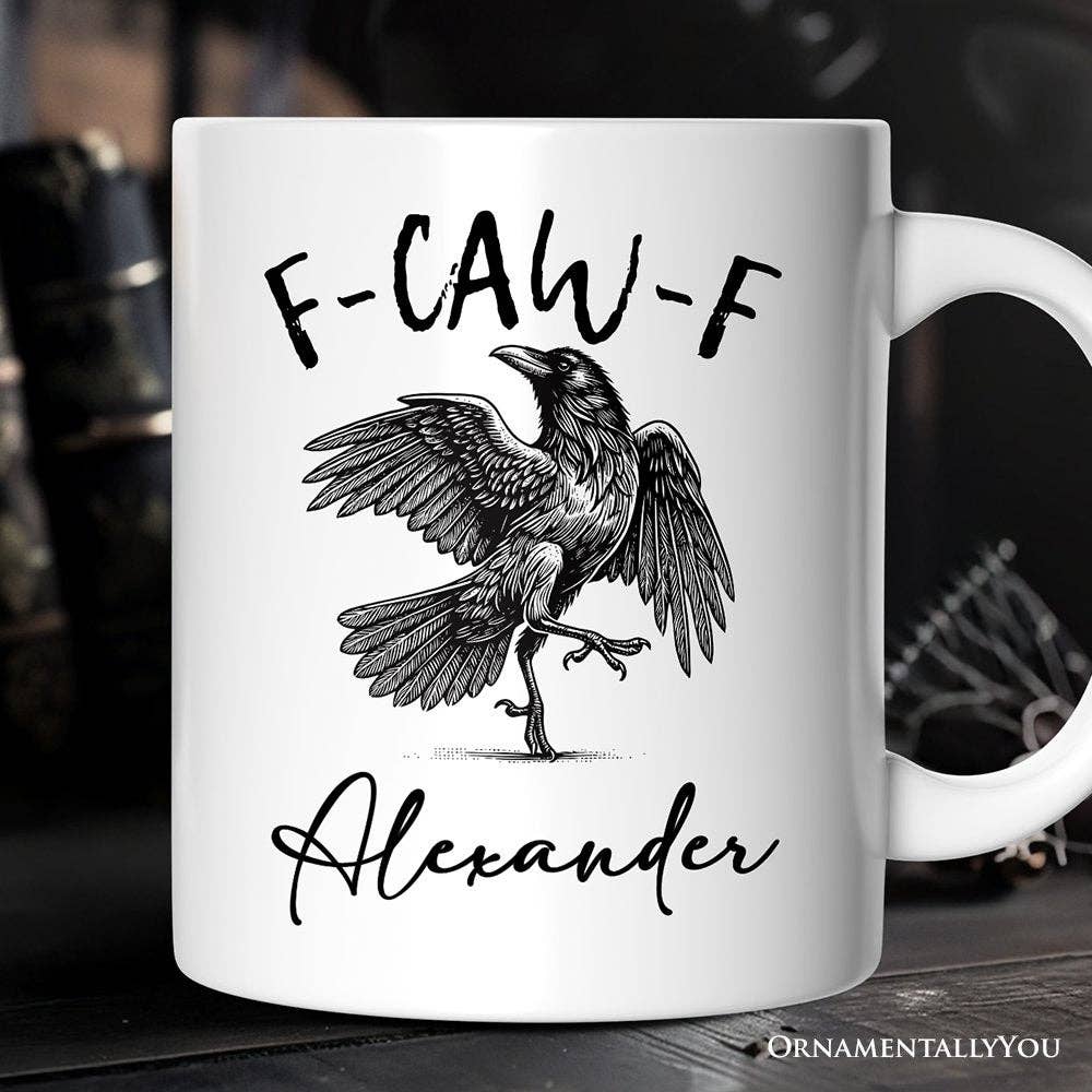 White mug with a black crow illustration and text on a dark background